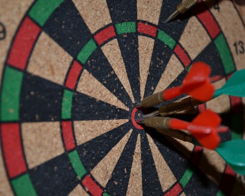 dartboard with several arrows in the bullseye