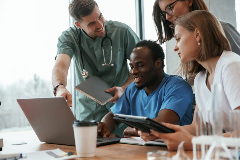 doctors and healthcare professionals review healthcare marketing strategy on laptop